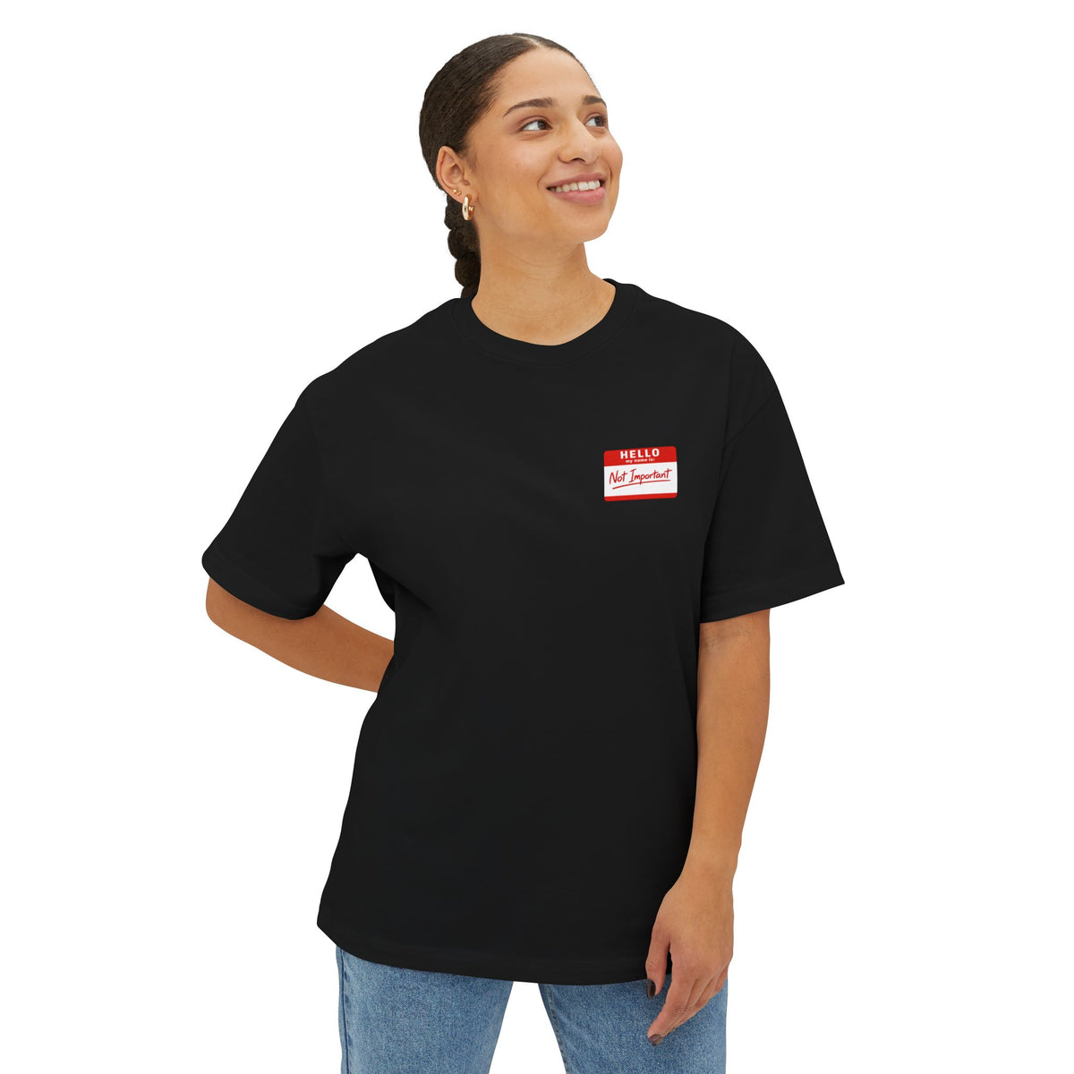 Person wearing a black t-shirt with a red and white name tag on a white background
